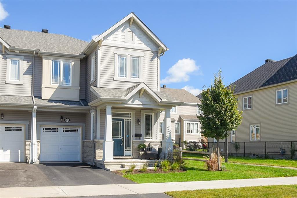 Houses for sale in Kanata - Picture of a beautiful townhouse with blue sky and green grass in the front yard