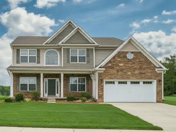 Stittsville Home by Jason Polonski. A two-story house in Stittsville with a lush green lawn extending from its base. The house is adorned with brown brick, giving it a sturdy and traditional appearance.